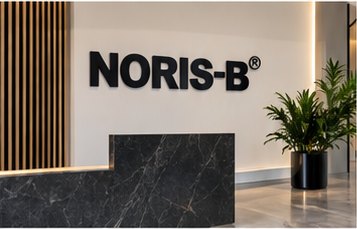 NORIS-B in heavy black letters on a marble office wall
