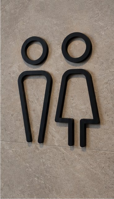 Black outline restroom figures on a stone wall